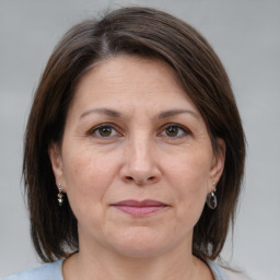 Joyful white adult female with medium  brown hair and grey eyes