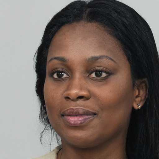 Joyful black young-adult female with long  black hair and brown eyes