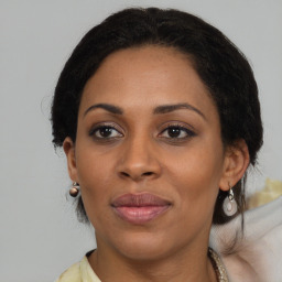 Joyful black adult female with medium  brown hair and brown eyes