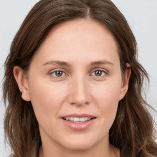 Joyful white young-adult female with long  brown hair and grey eyes