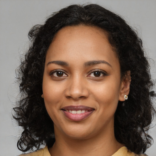Joyful black young-adult female with long  brown hair and brown eyes