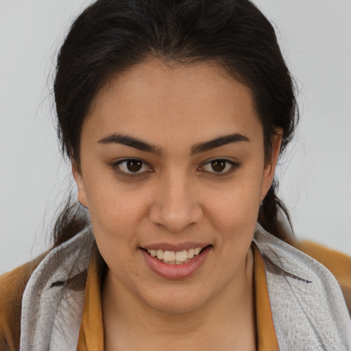 Joyful latino young-adult female with medium  brown hair and brown eyes