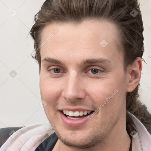 Joyful white young-adult male with short  brown hair and grey eyes