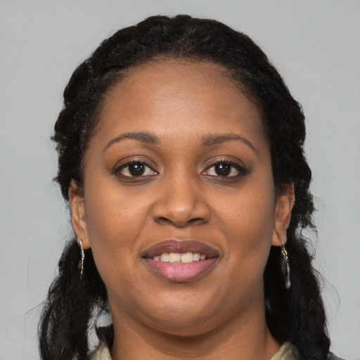 Joyful black young-adult female with long  black hair and brown eyes
