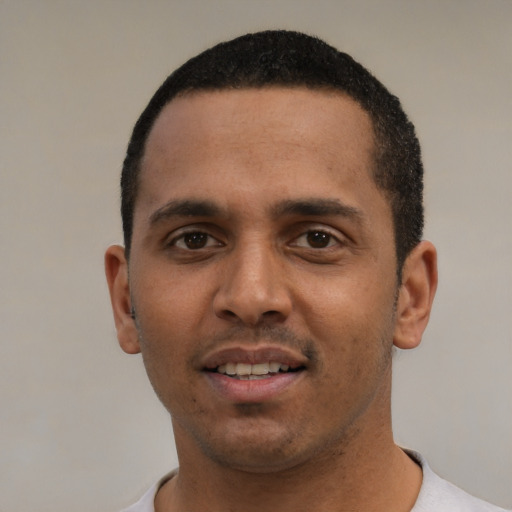 Joyful white young-adult male with short  black hair and brown eyes