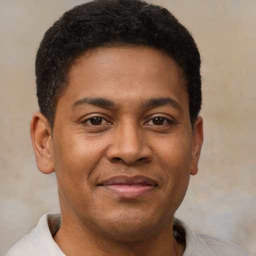 Joyful black young-adult male with short  brown hair and brown eyes