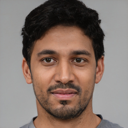 Joyful latino young-adult male with short  black hair and brown eyes