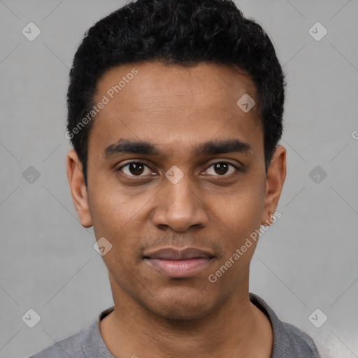 Joyful black young-adult male with short  black hair and brown eyes