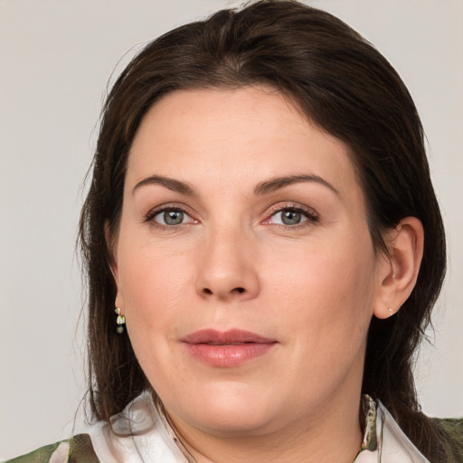 Joyful white young-adult female with medium  brown hair and green eyes