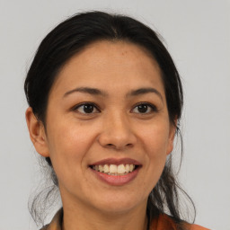 Joyful latino adult female with medium  brown hair and brown eyes