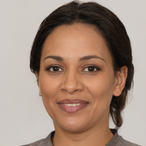Joyful latino adult female with medium  brown hair and brown eyes