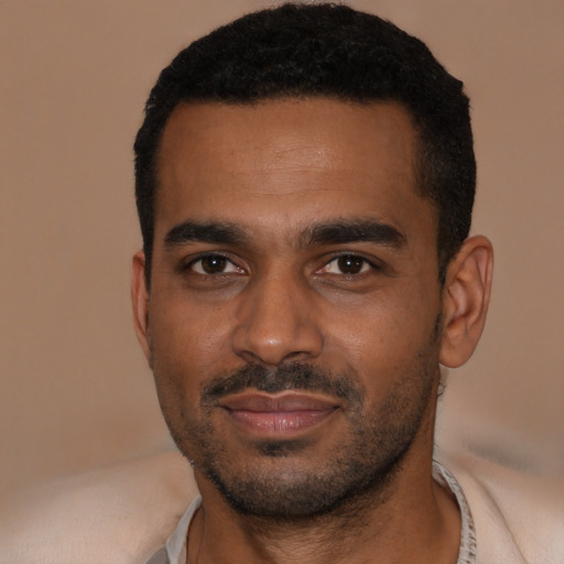 Joyful black young-adult male with short  black hair and brown eyes
