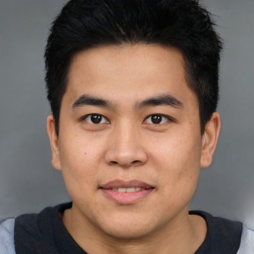 Joyful asian young-adult male with short  brown hair and brown eyes