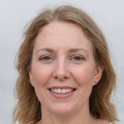 Joyful white adult female with long  brown hair and grey eyes