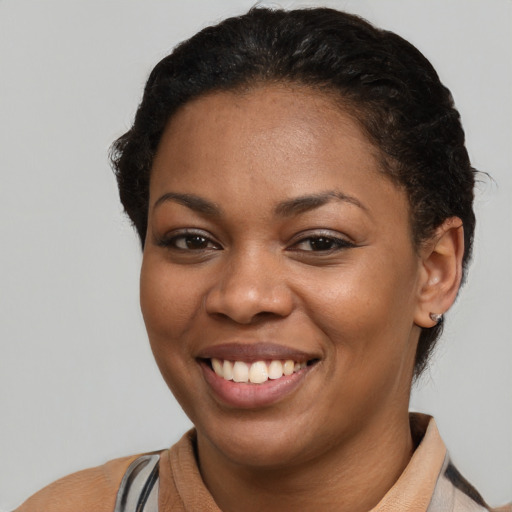 Joyful black young-adult female with short  brown hair and brown eyes