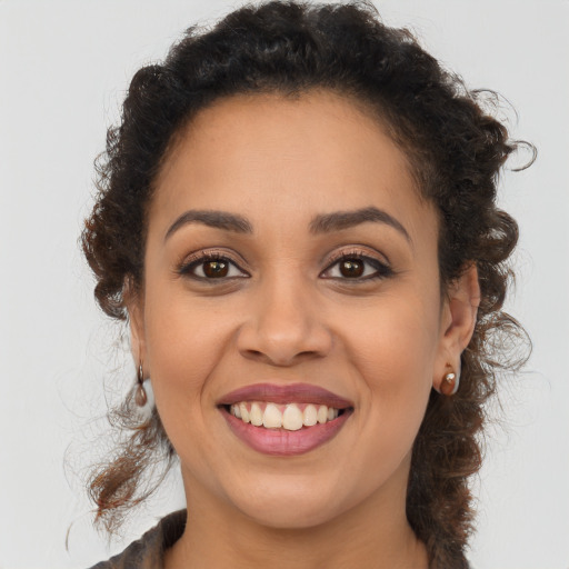 Joyful black young-adult female with long  brown hair and brown eyes