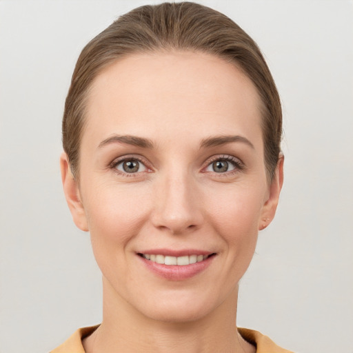 Joyful white young-adult female with short  brown hair and grey eyes