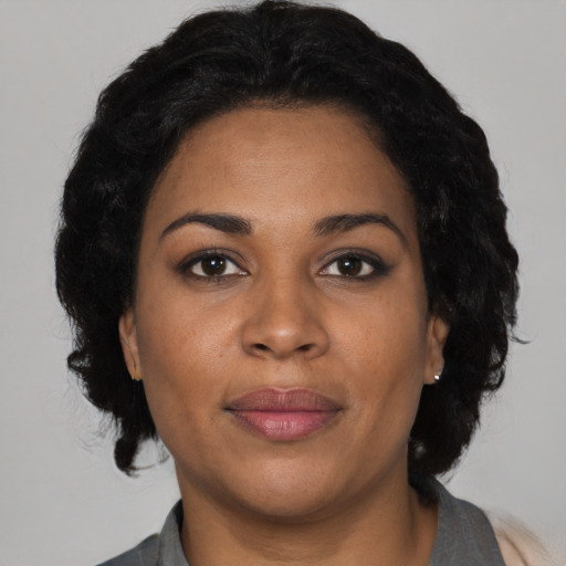 Joyful black adult female with medium  black hair and brown eyes