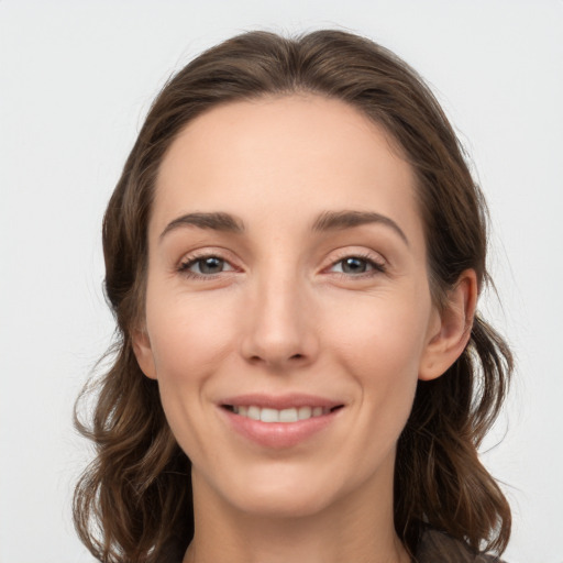 Joyful white young-adult female with medium  brown hair and grey eyes