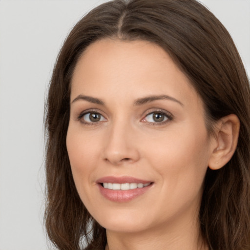 Joyful white young-adult female with long  brown hair and brown eyes