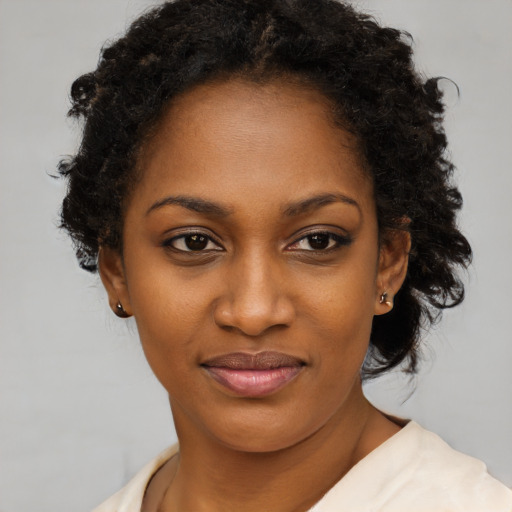 Joyful black young-adult female with short  brown hair and brown eyes