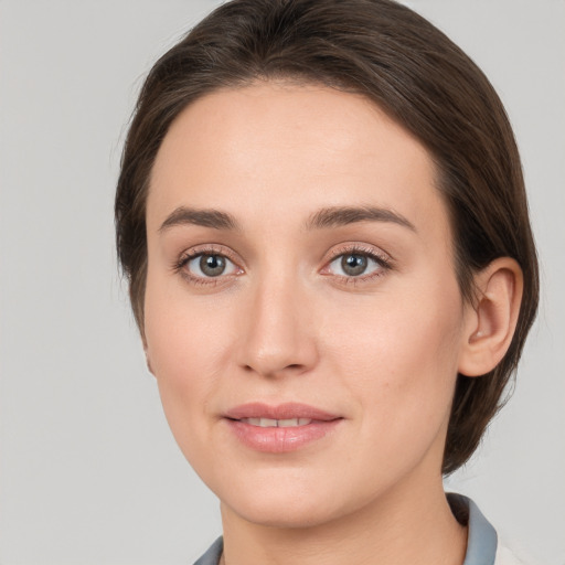 Joyful white young-adult female with medium  brown hair and grey eyes