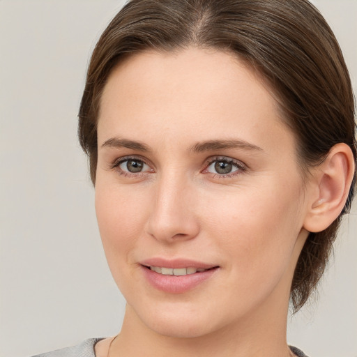 Joyful white young-adult female with medium  brown hair and grey eyes