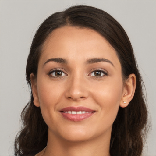 Joyful white young-adult female with long  brown hair and brown eyes