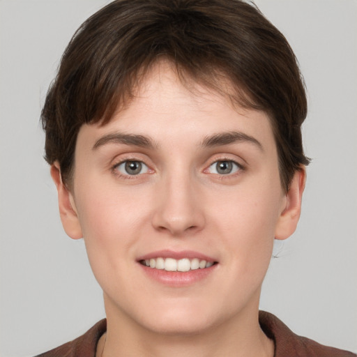 Joyful white young-adult female with short  brown hair and grey eyes