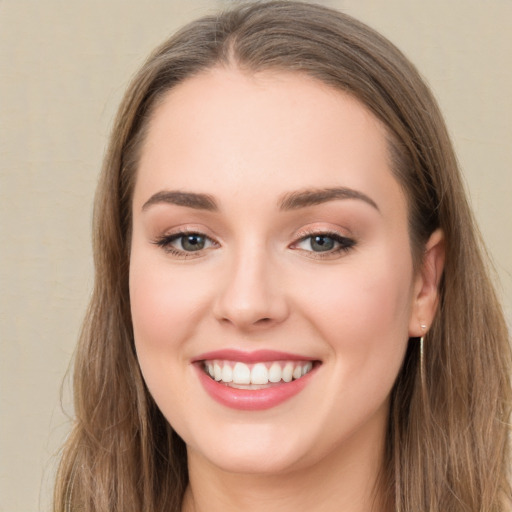 Joyful white young-adult female with long  brown hair and green eyes