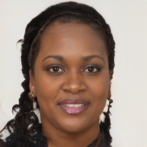 Joyful black young-adult female with long  brown hair and brown eyes