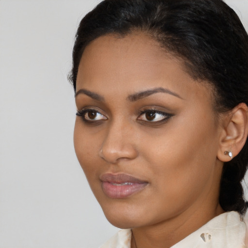 Joyful black young-adult female with medium  brown hair and brown eyes