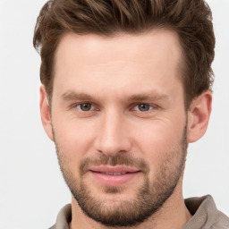 Joyful white young-adult male with short  brown hair and grey eyes