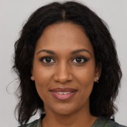 Joyful black adult female with long  brown hair and brown eyes