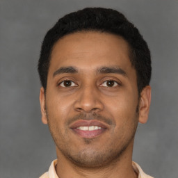 Joyful latino young-adult male with short  brown hair and brown eyes