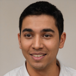 Joyful latino young-adult male with short  black hair and brown eyes