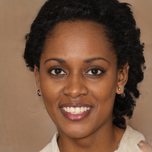 Joyful black young-adult female with medium  black hair and brown eyes