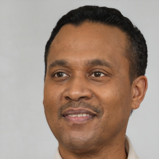 Joyful black adult male with short  black hair and brown eyes