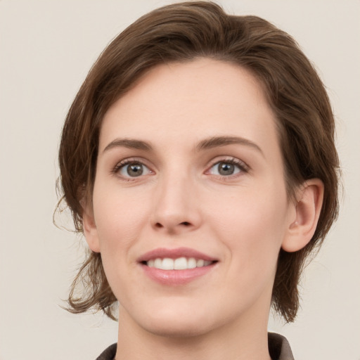 Joyful white young-adult female with medium  brown hair and green eyes