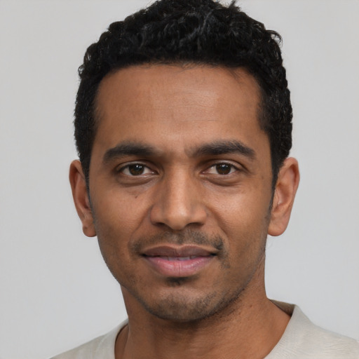 Joyful black young-adult male with short  black hair and brown eyes