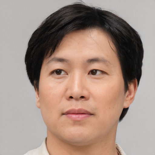 Joyful asian adult male with short  brown hair and brown eyes
