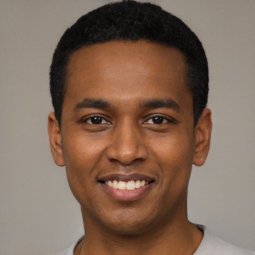 Joyful black young-adult male with short  black hair and brown eyes