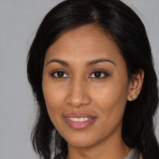 Joyful black young-adult female with long  brown hair and brown eyes