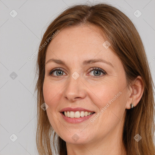 Joyful white adult female with long  brown hair and grey eyes