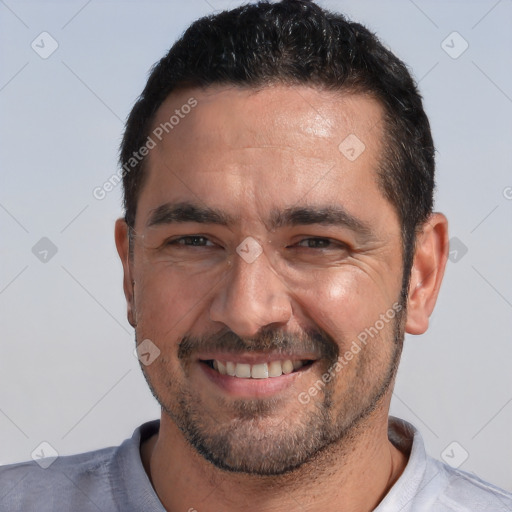 Joyful white adult male with short  black hair and brown eyes