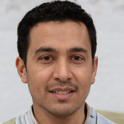 Joyful white young-adult male with short  black hair and brown eyes