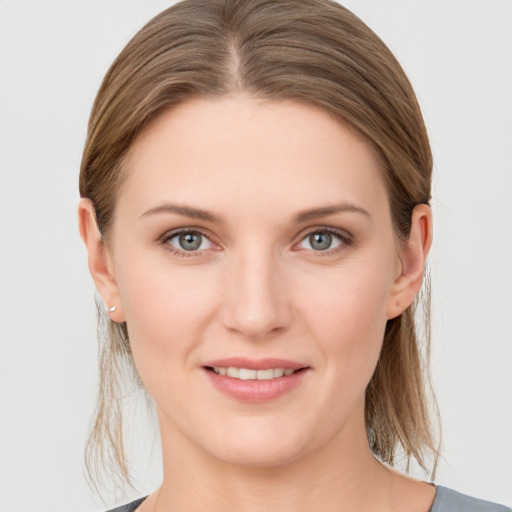 Joyful white young-adult female with medium  brown hair and grey eyes