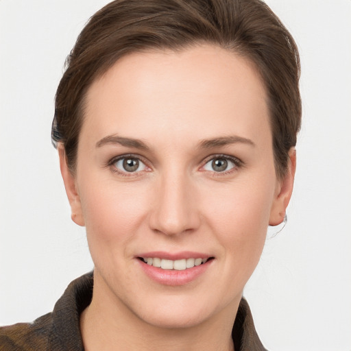 Joyful white young-adult female with short  brown hair and grey eyes