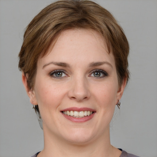 Joyful white young-adult female with medium  brown hair and grey eyes