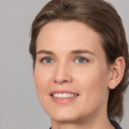 Joyful white young-adult female with medium  brown hair and grey eyes